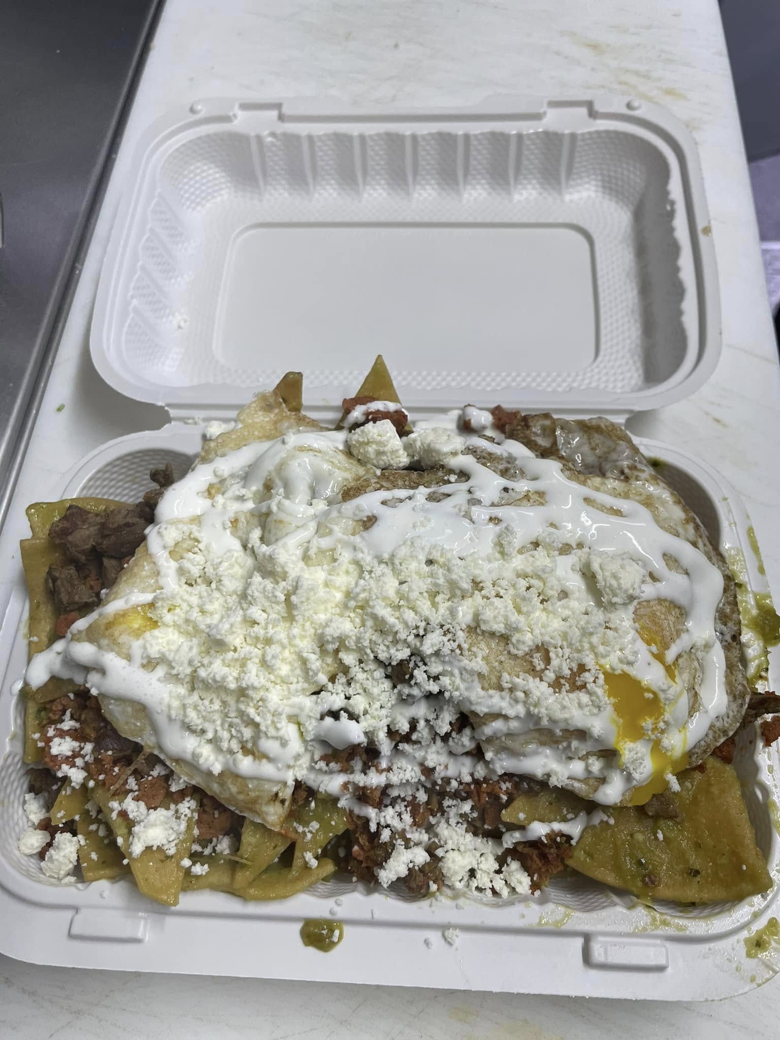 Chilaquiles topped with a fried egg, crema, and crumbled queso fresco